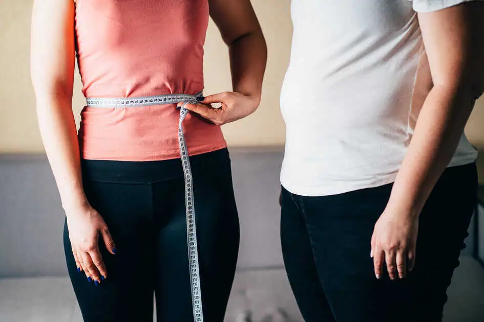 Women measuring waist for personalized weight loss and fitness plans